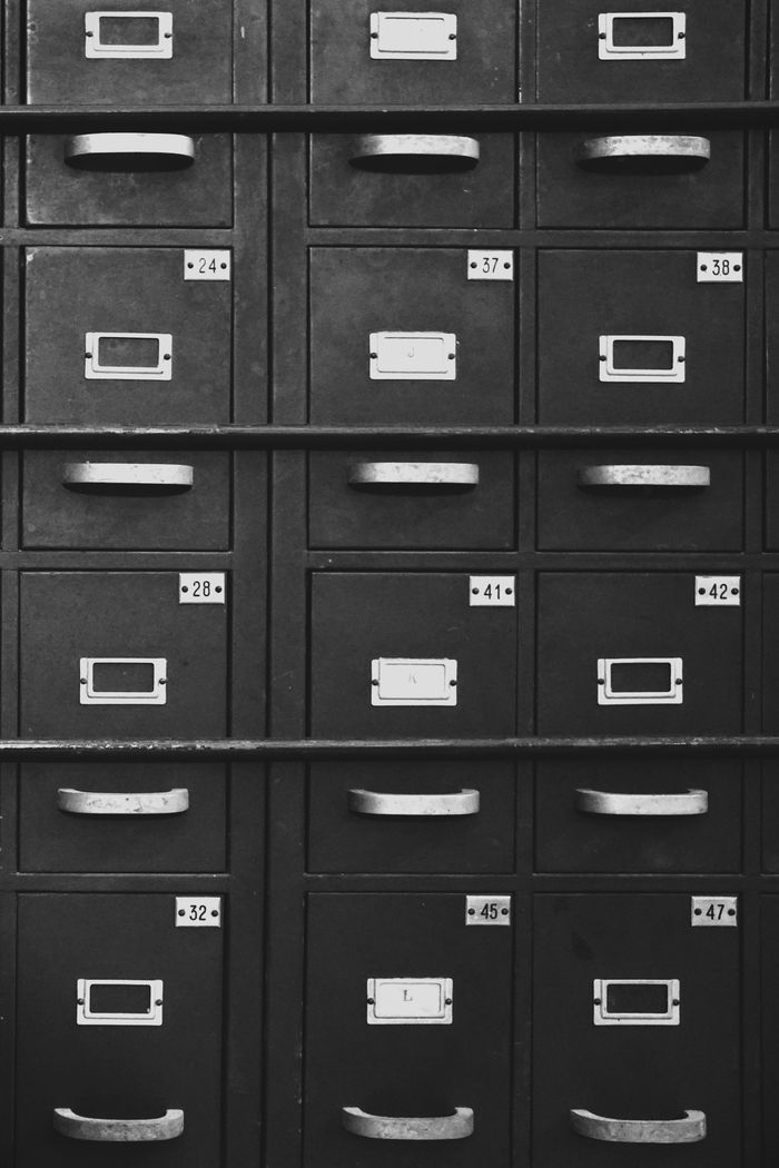 Black and white image of vintage metal filing cabinets with numbers for organizing documents.